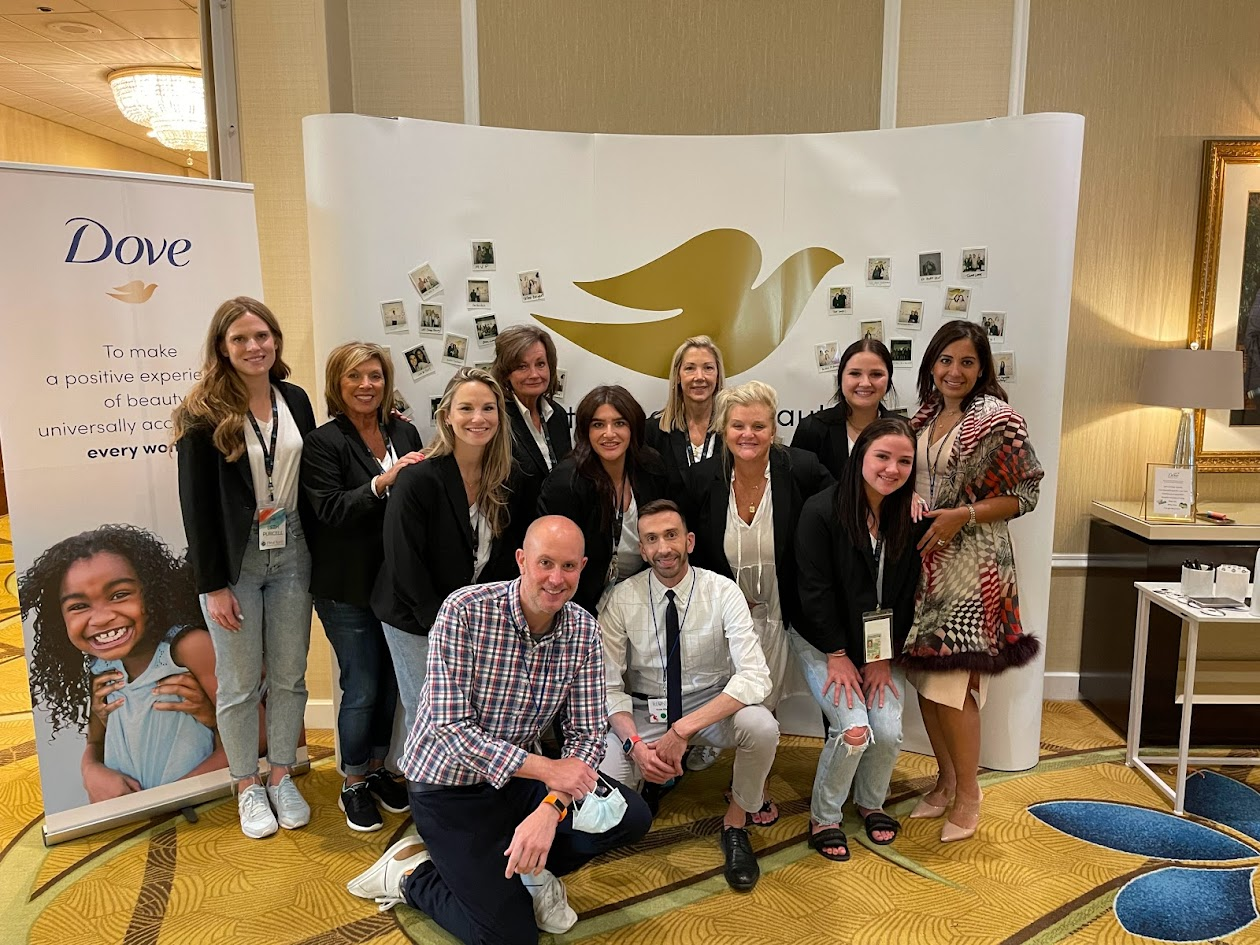 Dove brand team group photo in front of branded backdrop