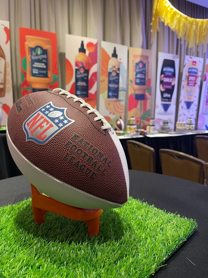 NFL football centerpiece on turf with sponsor backdrop