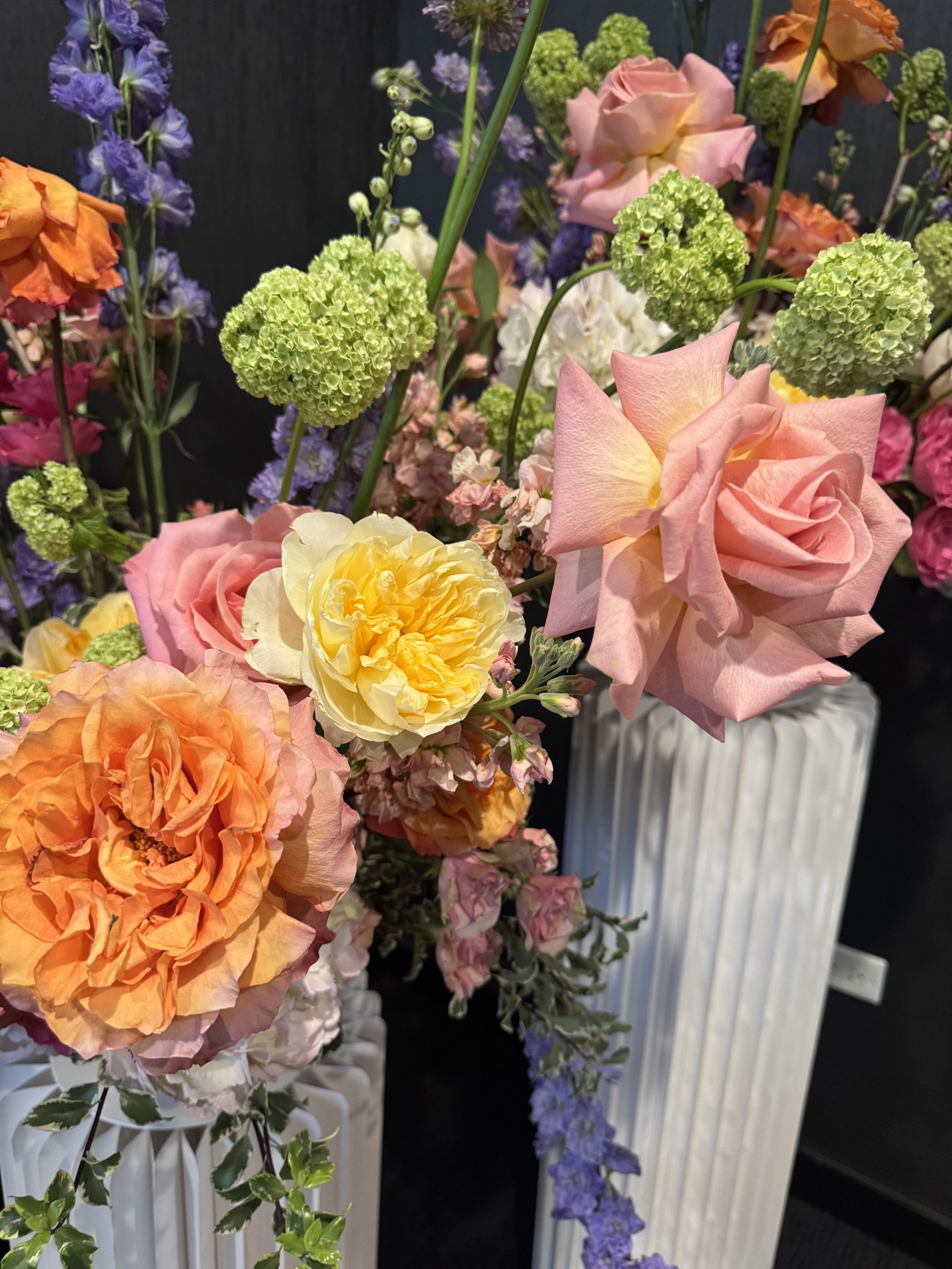 Pastel floral arrangements on white pedestals